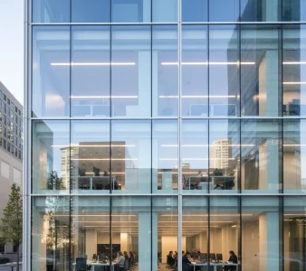 Clean glass windows on a modern multi-story office building in downtown Sacramento, reflecting nearby buildings after professional commercial window cleaning service.