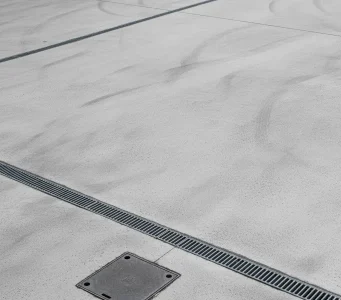 Clean and freshly pressure washed concrete surface in a parking lot in Roseville, showing clear drainage channels and no visible dirt or stains.