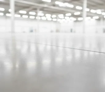 Clean and polished warehouse floor in a large industrial building in Sacramento, professionally pressure washed and ready for use.
